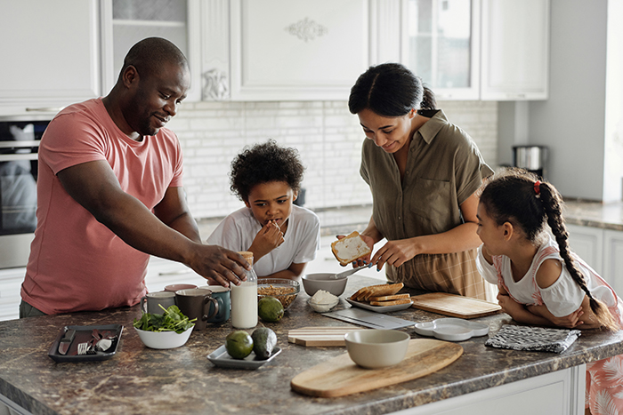 A family gathered around a kitchen island preparing a meal together