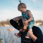 A father carrying his young daughter on his shoulders