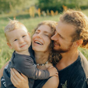 A picture of a smiling mother, father, and young child.