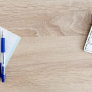 An image of a blank notebook and computer keyboard on a desk.